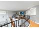 View of the loft featuring decorative railings, wood floors, and a sitting area with a large television at 12134 Shadowbrook Ln, Orlando, FL 32828
