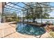 Screened in pool with a waterfall feature and nearby gazebo that has scenic lake views at 12134 Shadowbrook Ln, Orlando, FL 32828