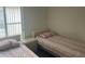 Bright bedroom showcasing two twin beds and a sunlit window with neutral decor at 123 S Roma Way, Kissimmee, FL 34746