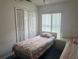 Cozy bedroom featuring twin beds, bi-fold closet doors, and a sunlit window at 123 S Roma Way, Kissimmee, FL 34746