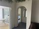 Hallway with archway leading to a bedroom with neutral carpet and sliding doors to the lanai at 123 S Roma Way, Kissimmee, FL 34746