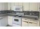 Well-equipped kitchen boasts white appliances and ample counter space at 123 S Roma Way, Kissimmee, FL 34746
