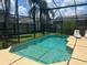 Beautiful in-ground pool surrounded by a screened enclosure and landscaping at 123 S Roma Way, Kissimmee, FL 34746