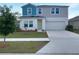 Two-story home with blue and gray siding, white trim, manicured lawn, and a two-car garage at 1404 Axel Cir, Winter Haven, FL 33880