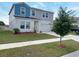 A two-story home with blue and gray siding, a manicured lawn, and a two-car garage at 1404 Axel Cir, Winter Haven, FL 33880
