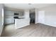 Modern kitchen with gray cabinets, stainless steel appliances, kitchen island with sink, and wood flooring at 1404 Axel Cir, Winter Haven, FL 33880