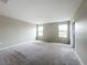 An expansive bedroom with plush gray carpeting, two windows, and neutral-toned walls at 1404 Axel Cir, Winter Haven, FL 33880
