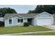 Charming single-story home with a well-maintained lawn, attached garage, and neutral-colored exterior at 1427 Orchid Ln, Kissimmee, FL 34744