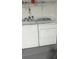 Neat laundry area with a washer and dryer, white walls, and simple shelving at 1427 Orchid Ln, Kissimmee, FL 34744