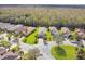 An aerial view shows homes with verdant lawns and mature trees on a cul-de-sac street in the neighborhood at 1703 Encinitas Way, Kissimmee, FL 34759