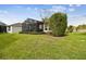 Well-manicured backyard with lush green grass, manicured shrubs, and a screened-in patio at 1703 Encinitas Way, Kissimmee, FL 34759