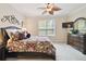 Comfortable bedroom featuring a decorative ceiling fan, neutral walls, and dark wood furnishings at 1703 Encinitas Way, Kissimmee, FL 34759
