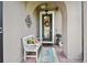 Inviting covered front porch with a cozy bench, decorative wreath, and decorative wall art at 1703 Encinitas Way, Kissimmee, FL 34759