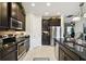 Modern kitchen features stainless steel appliances, dark cabinets, and granite countertops at 1703 Encinitas Way, Kissimmee, FL 34759