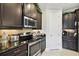 Well-equipped kitchen featuring stainless steel appliances, dark cabinetry, and granite countertops at 1703 Encinitas Way, Kissimmee, FL 34759