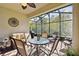 Relaxing screened-in patio with comfortable seating, a ceiling fan, and view of wooded area at 1703 Encinitas Way, Kissimmee, FL 34759