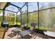Relaxing screened patio with lounge chairs, brick flooring, and a view of the surrounding greenery at 1703 Encinitas Way, Kissimmee, FL 34759
