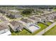 Expansive aerial view of a neighborhood featuring modern homes, a community pool, and a serene lake at 1765 Petiole Pl, Kissimmee, FL 34744