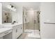 Bright bathroom with gray tile flooring, single vanity sink, modern fixtures, and glass shower at 1765 Petiole Pl, Kissimmee, FL 34744