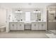 Bright bathroom with gray tile flooring, double vanity sinks, modern fixtures, and glass shower at 1765 Petiole Pl, Kissimmee, FL 34744