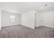 A spacious bedroom featuring neutral carpet, natural light, and minimalist modern design at 1765 Petiole Pl, Kissimmee, FL 34744