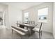 Inviting dining area with a modern table, chairs, bench, and natural light from the windows at 1765 Petiole Pl, Kissimmee, FL 34744