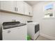 Bright laundry room featuring a Whirlpool washer/dryer and white cabinets for convenient storage at 1765 Petiole Pl, Kissimmee, FL 34744