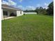 Spacious backyard with healthy green grass, a white vinyl fence and a covered patio with outdoor seating at 200 Citrine Loop, Kissimmee, FL 34758