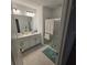 Bright bathroom featuring double vanity with white cabinets and a shower with sliding glass doors at 200 Citrine Loop, Kissimmee, FL 34758