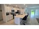 Modern kitchen with stainless steel appliances, white cabinetry, and a large island with bar seating at 200 Citrine Loop, Kissimmee, FL 34758