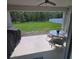 Covered patio with ceiling fan, table and chairs overlooking the well-manicured lawn and a wooded area at 200 Citrine Loop, Kissimmee, FL 34758