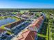 Extensive aerial view of the community near a lake, golf course, and a long street with mature trees at 2000 Greenbriar Ter, Davenport, FL 33837