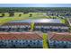 Aerial view of townhomes near a beautiful golf course and water feature surrounded by lush green trees at 2000 Greenbriar Ter, Davenport, FL 33837