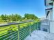 The balcony has a metal railing, and offers a view of the street, lawn, and landscaping at 2000 Greenbriar Ter, Davenport, FL 33837