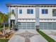 Modern townhouse featuring two garages, contemporary design, and well-manicured landscaping provides curb appeal at 2000 Greenbriar Ter, Davenport, FL 33837