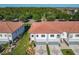 Two-story townhome with a red tile roof, well-maintained lawn, and a patterned driveway at 2000 Greenbriar Ter, Davenport, FL 33837