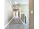 Bright hallway with neutral paint, carpet flooring, crown molding, and modern railing at 2000 Greenbriar Ter, Davenport, FL 33837