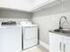 Laundry room features a washer, a dryer, a utility sink and white cabinets at 2000 Greenbriar Ter, Davenport, FL 33837