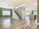 Bright, open-concept living space with wood floors and a modern staircase leading to the second floor at 2000 Greenbriar Ter, Davenport, FL 33837