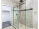 Modern bathroom showcasing an elegant glass-enclosed shower with tile and mosaic accents at 2000 Greenbriar Ter, Davenport, FL 33837