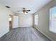 Open bedroom with two windows, a ceiling fan, vinyl floors, and light-colored walls at 2409 E Magnolia St, Lakeland, FL 33801
