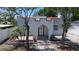 Charming home featuring a white stucco exterior, arched entry, and well-manicured landscaping at 2409 E Magnolia St, Lakeland, FL 33801