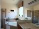Bright bathroom featuring a bathtub, shower, and a vanity with a large mirror at 2514 Dharma Cir, Kissimmee, FL 34746