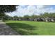 Scenic view of the community green space featuring lush trees and sidewalks with neighborhood homes at 2673 Rainbow Springs Ln, Orlando, FL 32828