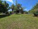 Property featuring a spacious backyard with mature trees and lush green grass at 2704 Sample St, Kissimmee, FL 34744