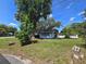 Property featuring a cozy home with a well-maintained lawn and mature trees at 2704 Sample St, Kissimmee, FL 34744