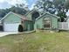 Charming single-Gathering home features a lush front lawn, mature trees, and a two-car garage at 2779 Theresa Dr, Kissimmee, FL 34744