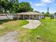 Spacious front yard with a concrete driveway leading to a charming, single-story home at 2947 Larson St, Kissimmee, FL 34741