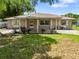 Charming single-story home featuring a covered front porch, stone facade, and well-maintained lawn at 2947 Larson St, Kissimmee, FL 34741