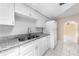 White kitchen cabinets with granite countertop, and white floor tiles at 2947 Larson St, Kissimmee, FL 34741